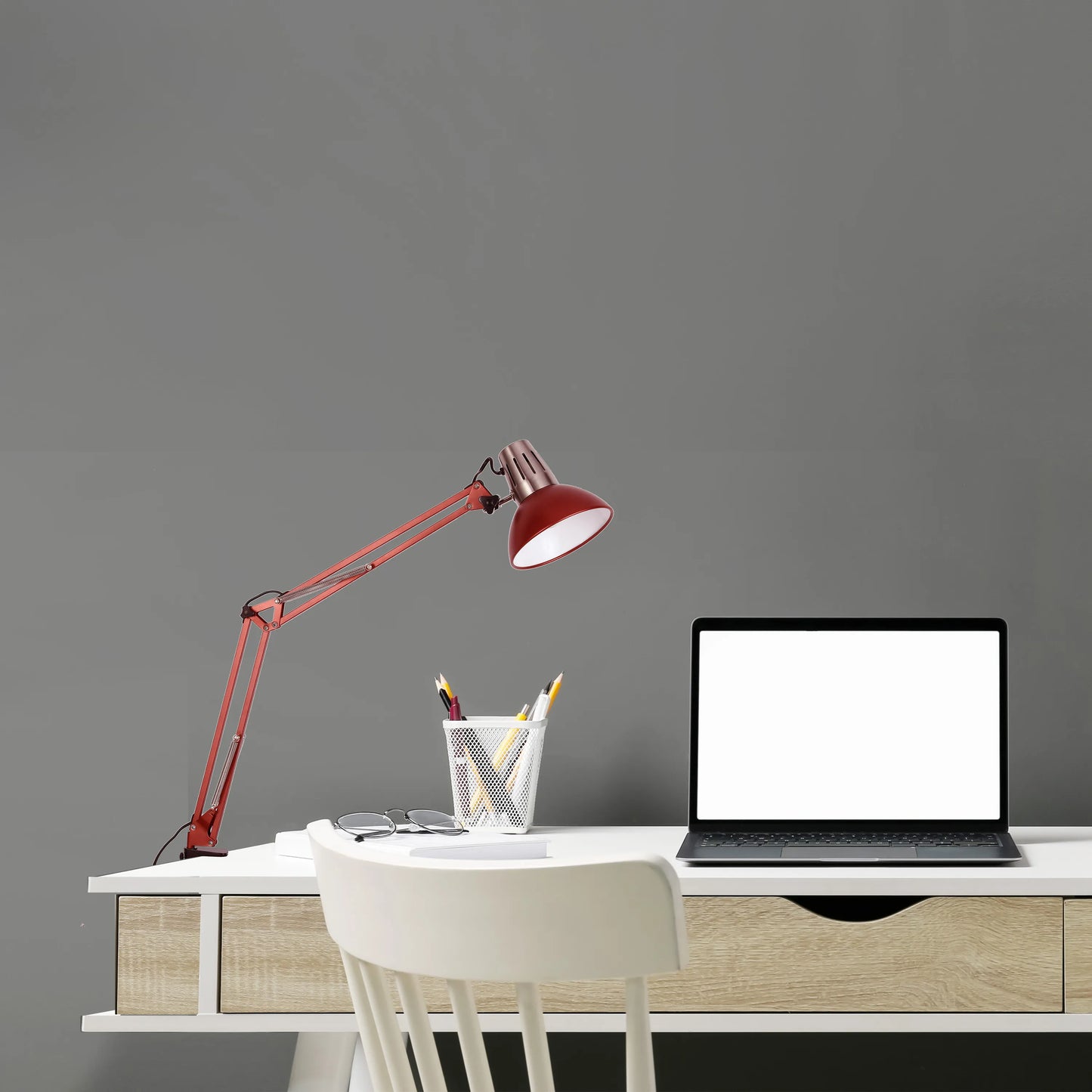 An adjustable red desk lamp illuminates a modern workspace, offering focused task lighting with a stylish design.