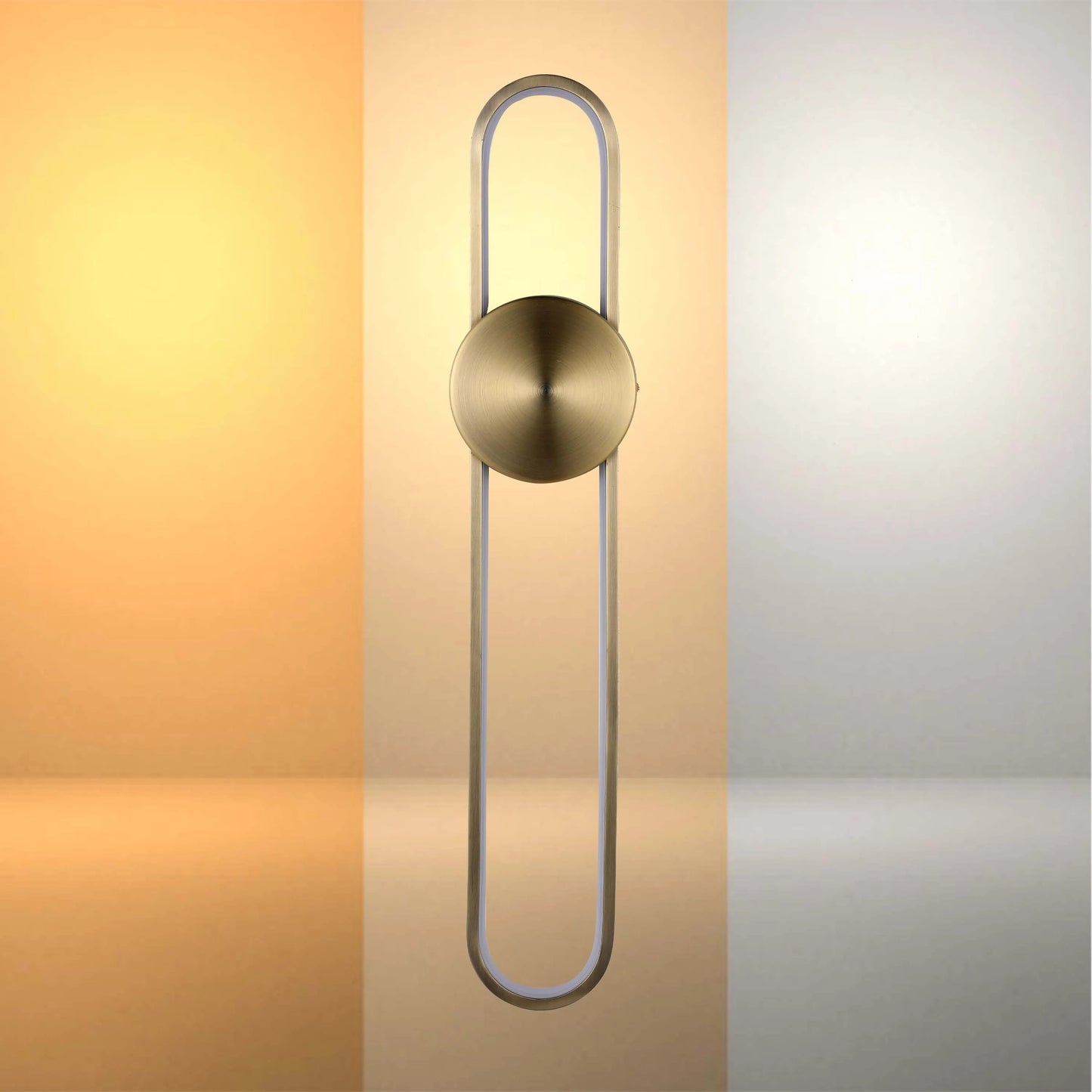 Modern wall light with warm and cool lighting options. Round brushed brass centre with rounded rectangular fixture.