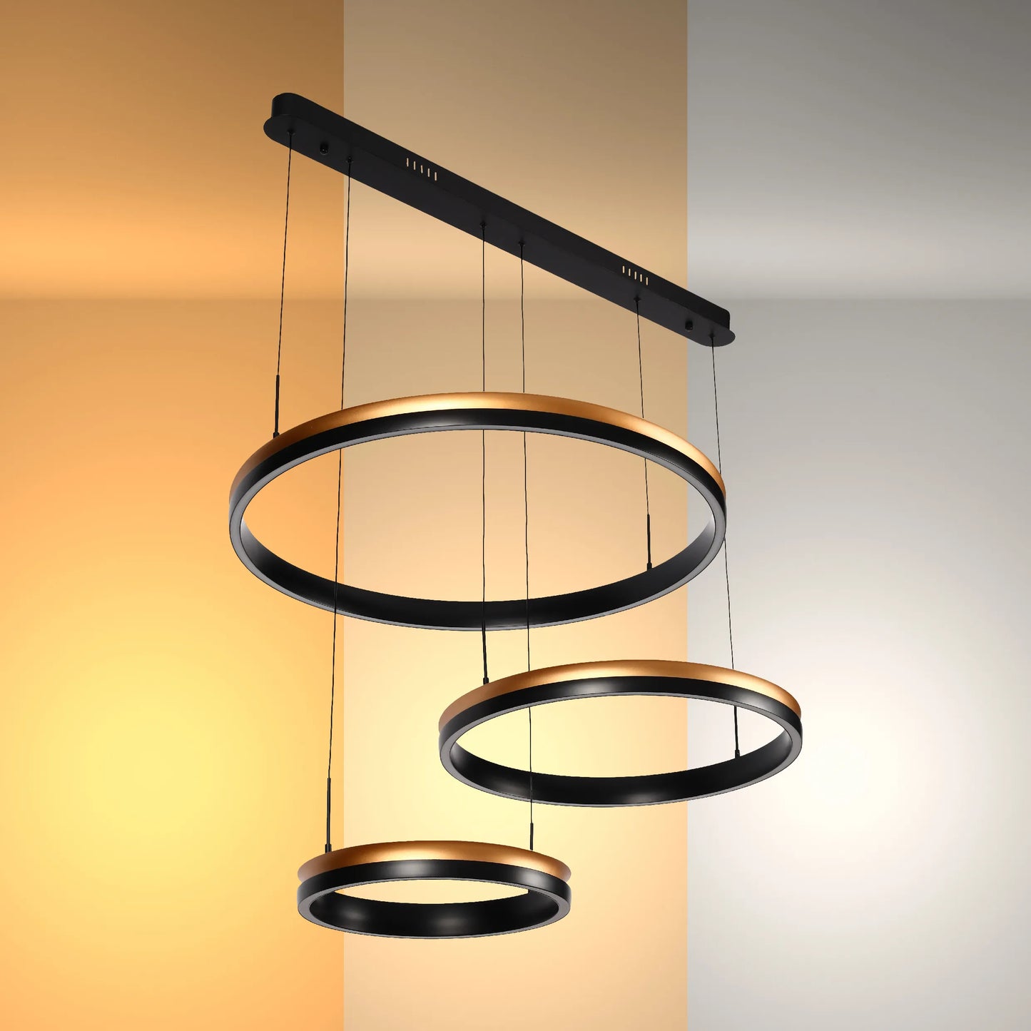 A modern chandelier with black and gold rings suspended at varying lengths from a long, black bar.