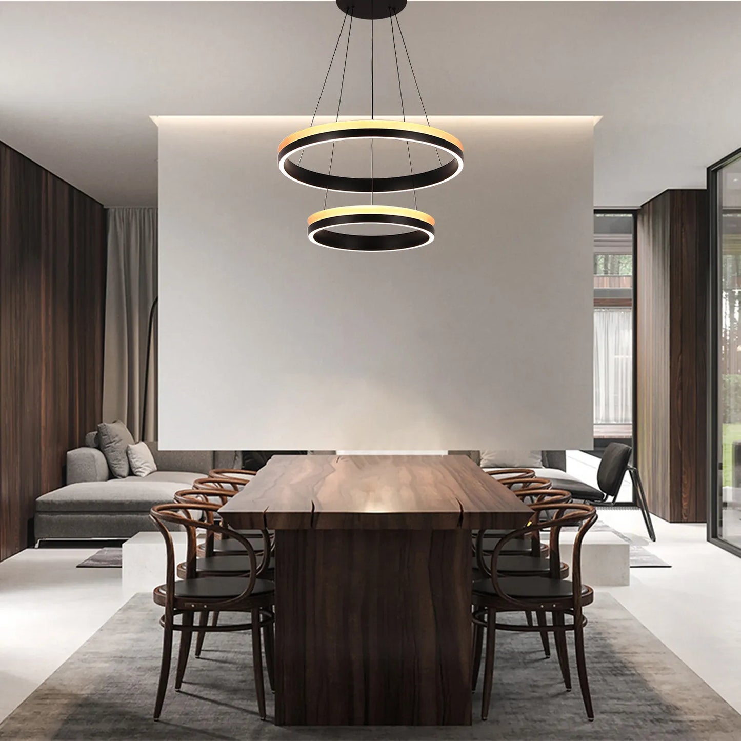 A contemporary two-tier ring pendant light hangs above a dark wood dining table, creating a modern and inviting atmosphere.