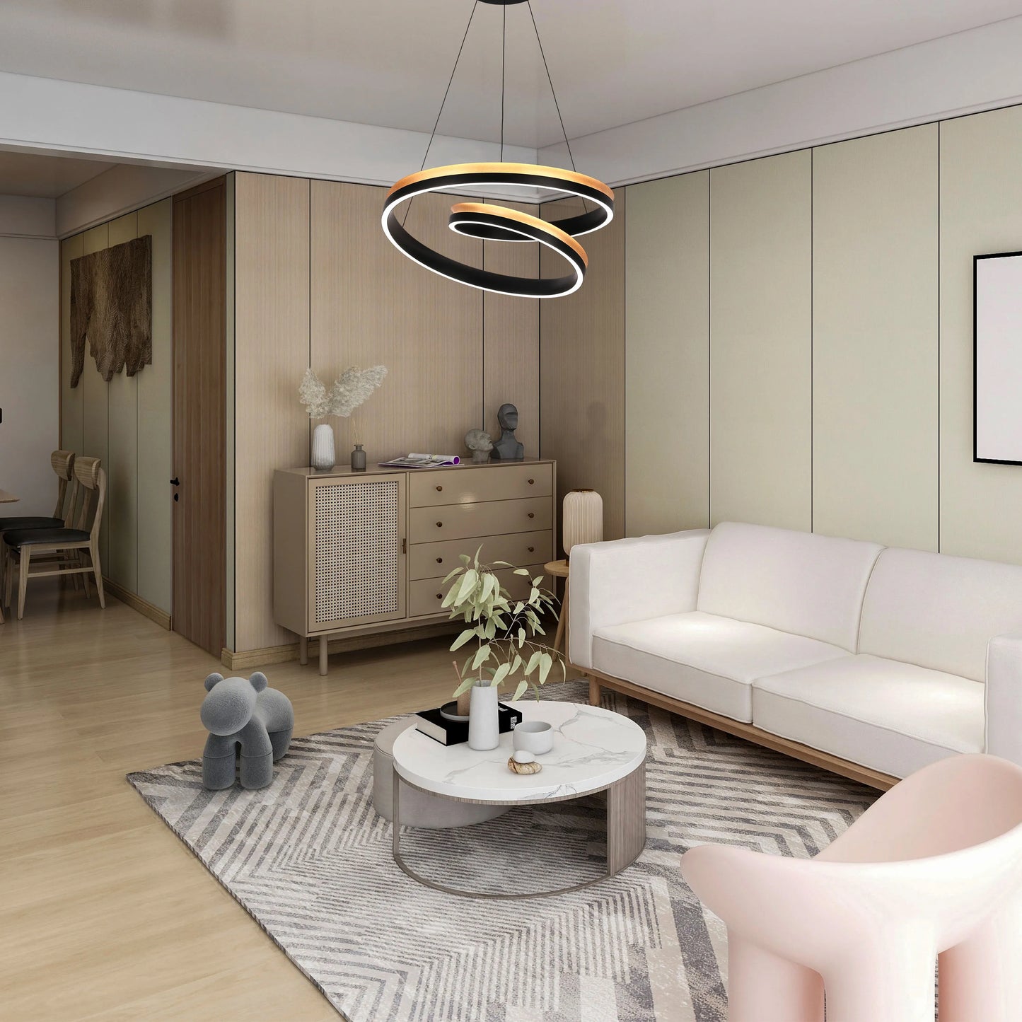 A modern, circular chandelier in black and gold tones hangs above the living area, providing ambient lighting.
