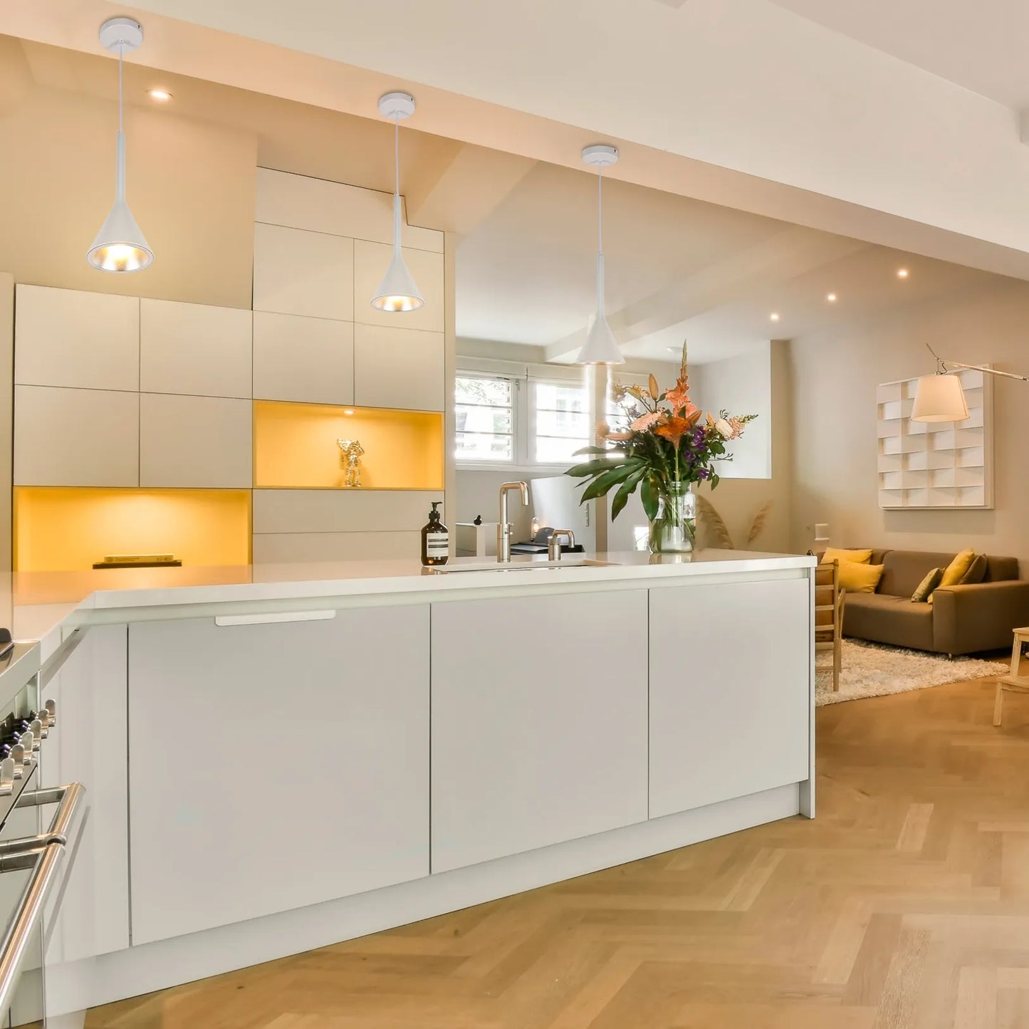 Contemporary kitchen lighting includes three cone-shaped pendant lights and in-cabinet spotlights, creating a warm and inviting atmosphere.