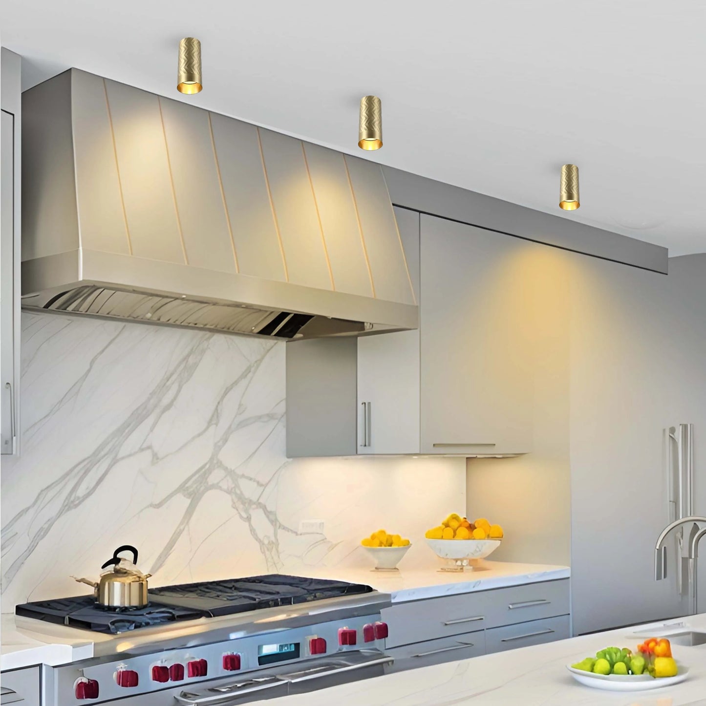 Contemporary kitchen with gold-coloured cylinder spotlights on the ceiling providing focused downlighting to illuminate the room.
