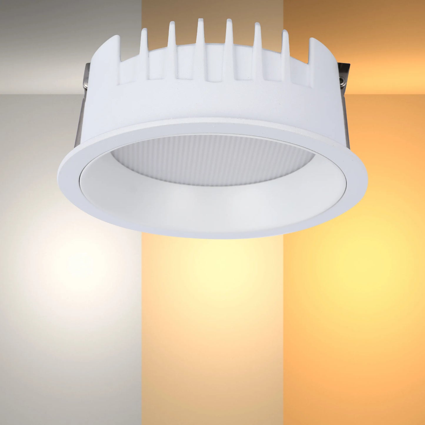 A modern recessed downlight with a white trim, showcasing various colour temperatures from warm to cool white lighting.