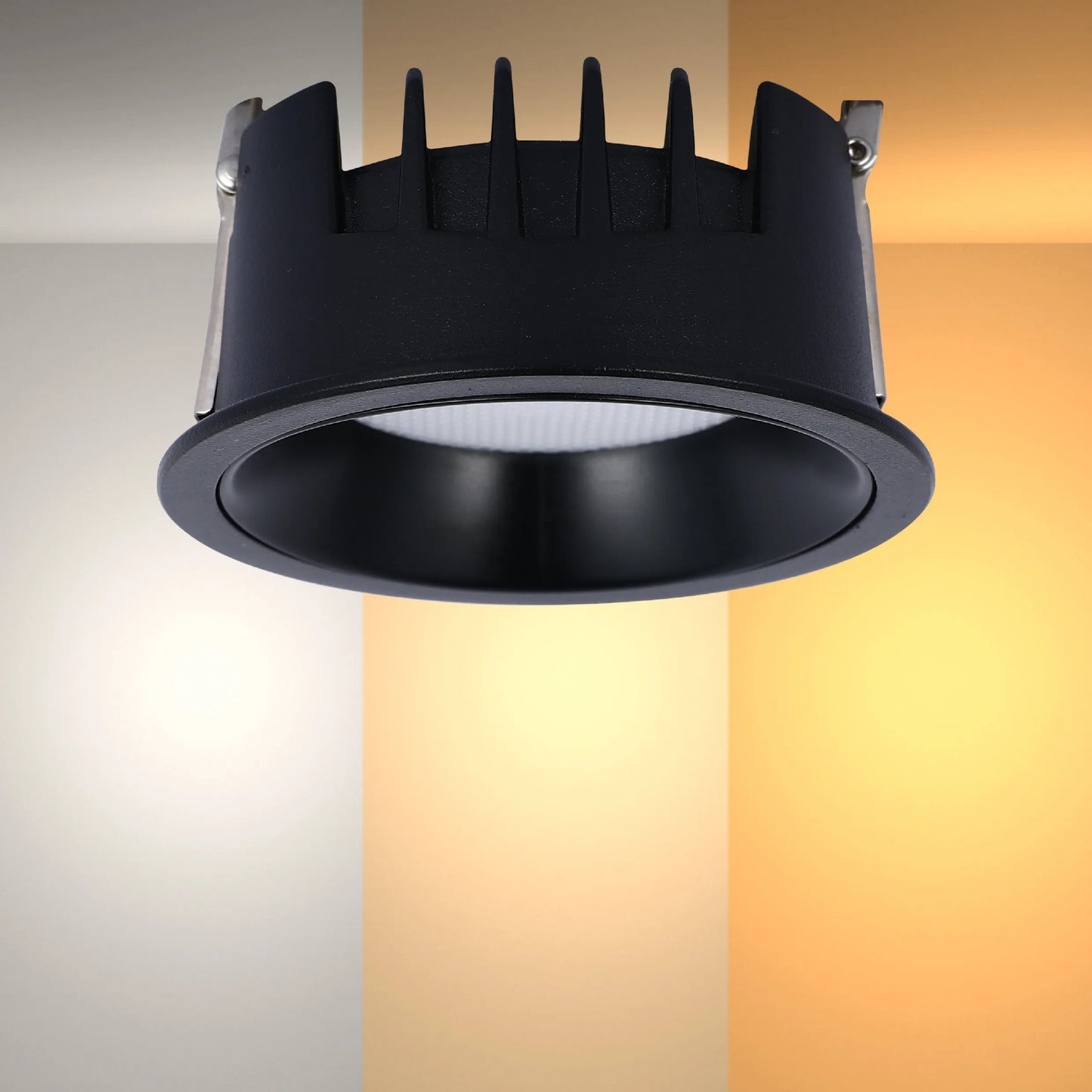 A black recessed downlight sits against a gradient background displaying the colour temperature changing from cool white to warm white.