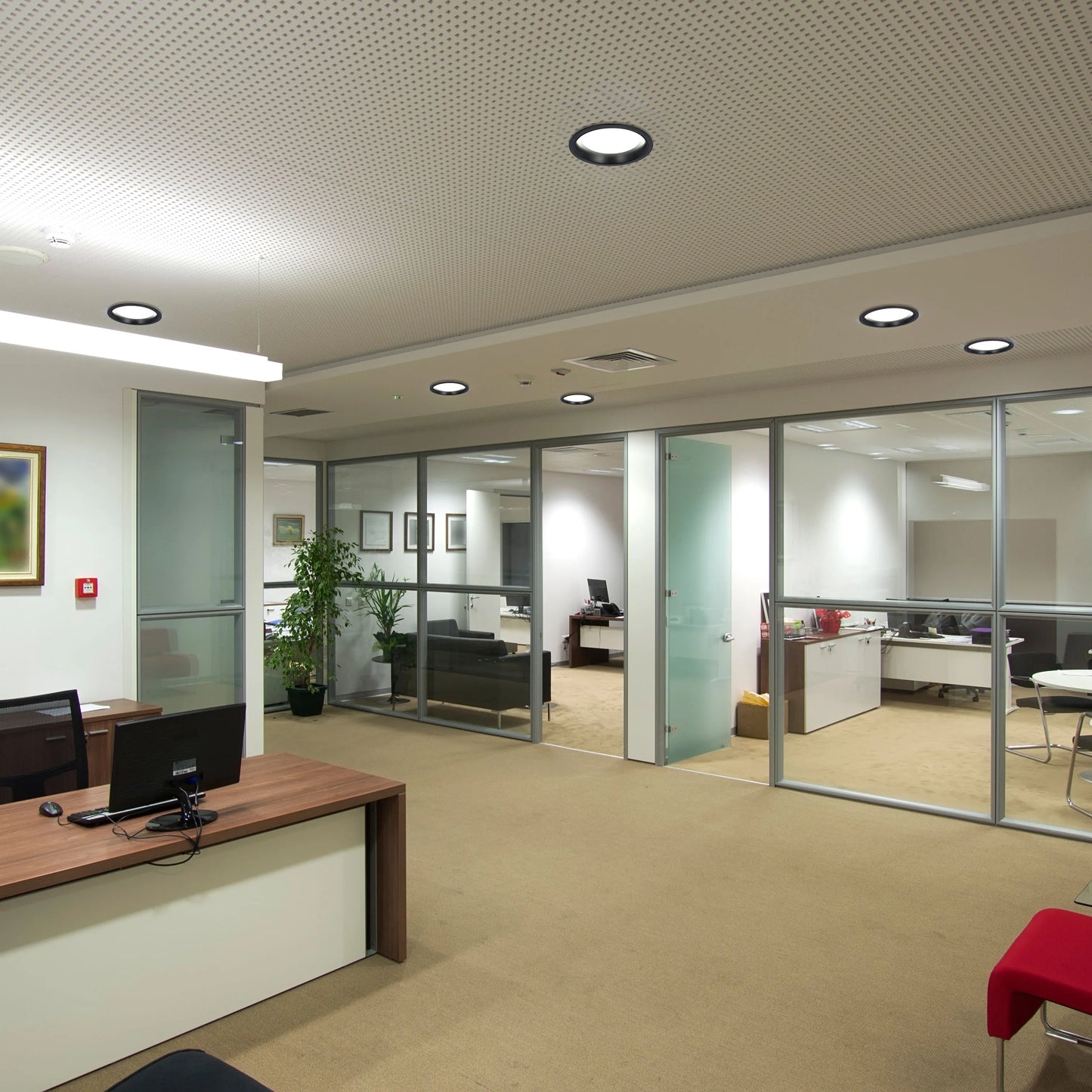 The office has a combination of recessed and linear lighting, creating a bright, functional and modern atmosphere.