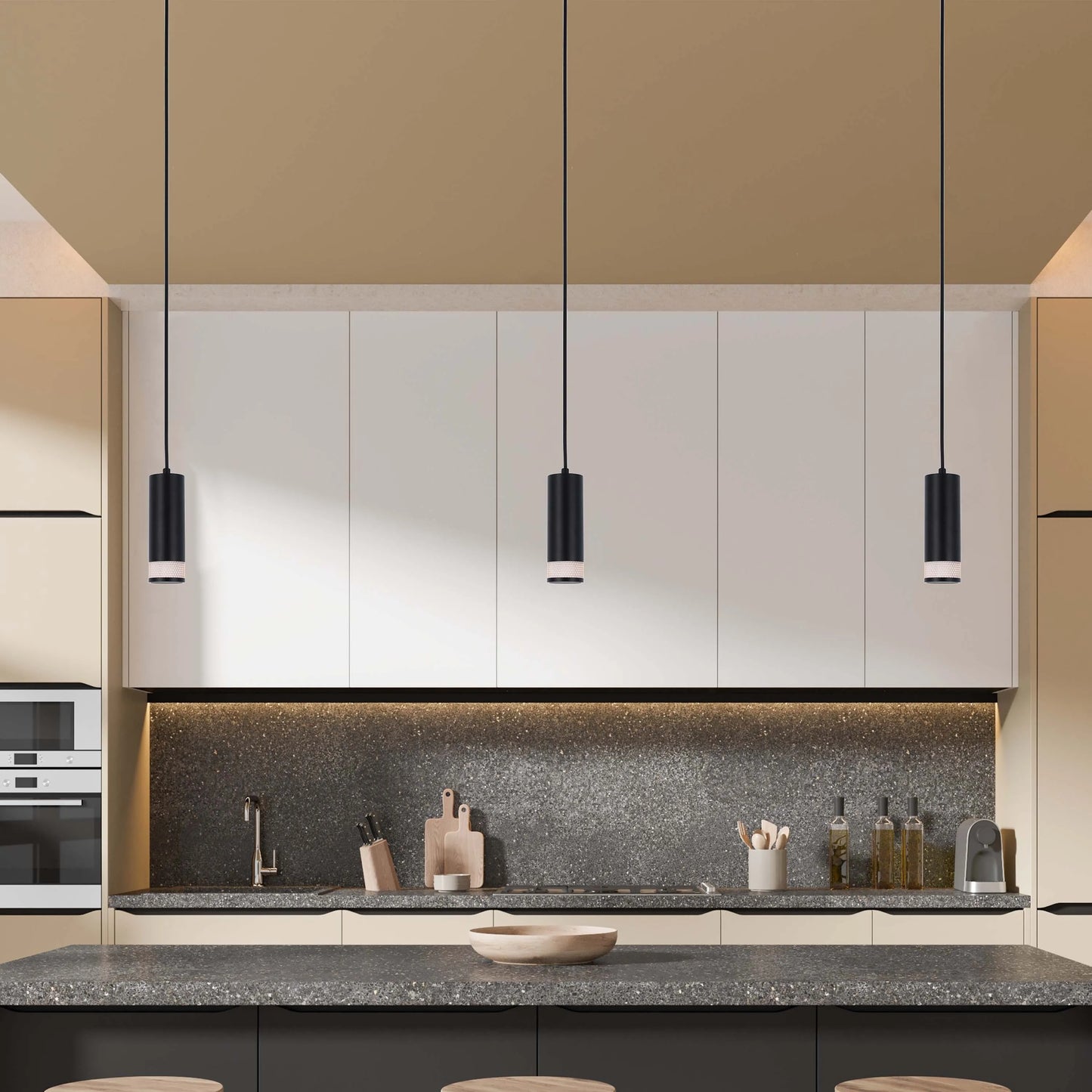Three black pendant lights hang above a kitchen island, providing focused illumination. The fixtures complement the modern kitchen design.