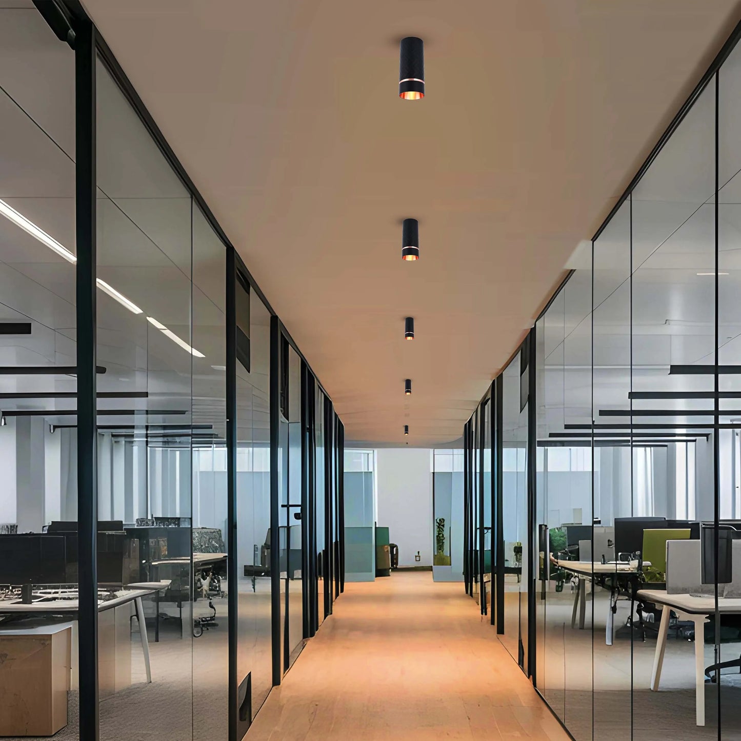 Hallway with sleek, cylindrical ceiling lights evenly spaced. Reflected light on the wood floor and glass walls creates a bright ambience.