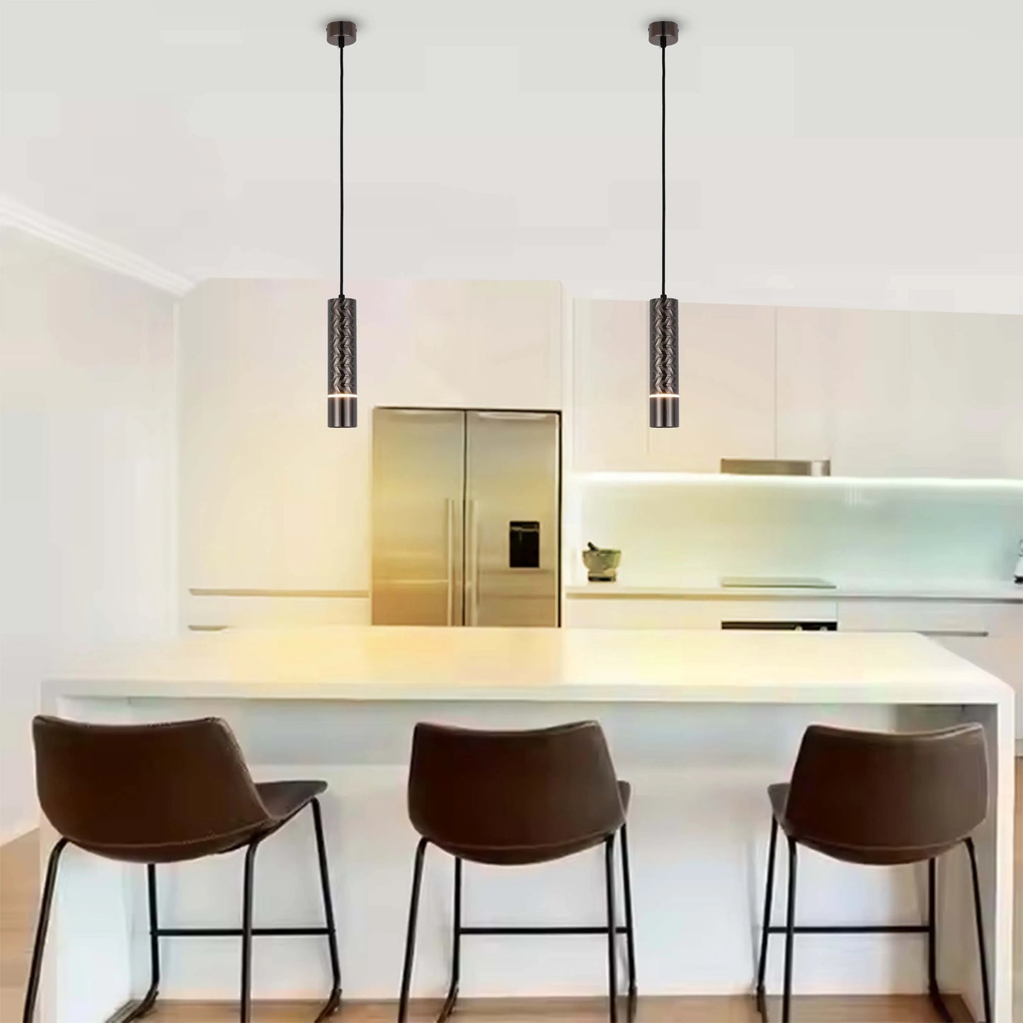 Two stylish cylindrical pendant lights hang above a kitchen island, providing focused illumination and a modern touch.
