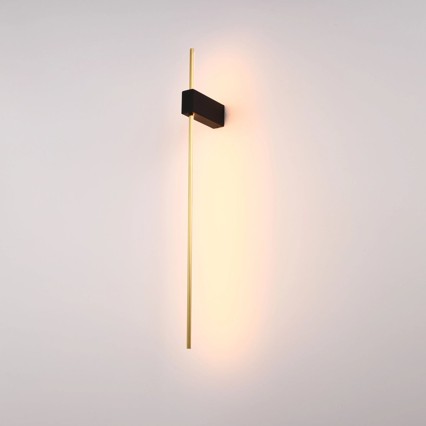 A modern, minimalist wall light with a sleek black fixture and a long, elegant gold rod, emitting a warm, inviting glow.