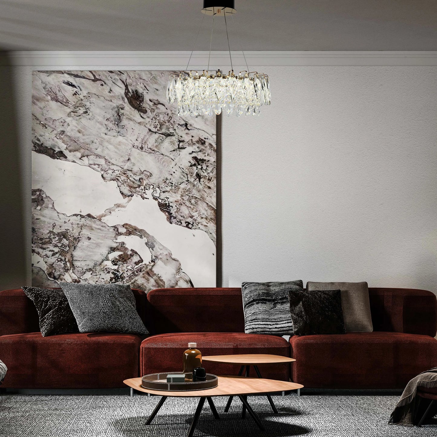 A round crystal chandelier hangs above a plush, reddish-brown sofa, creating a warm and inviting ambience in the living room.