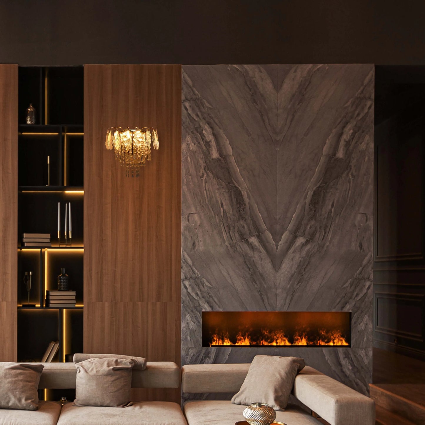 Chandelier and shelf lighting illuminate this space. Fire effect lighting gives a warm glow, offset by the cool marble backdrop.