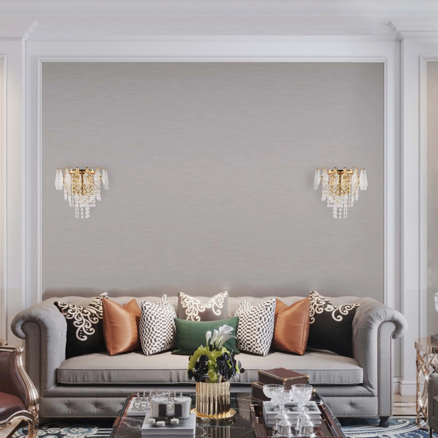 Crystal wall sconces add an elegant touch to this room, flanking a sofa with decorative pillows and marble-topped coffee table.