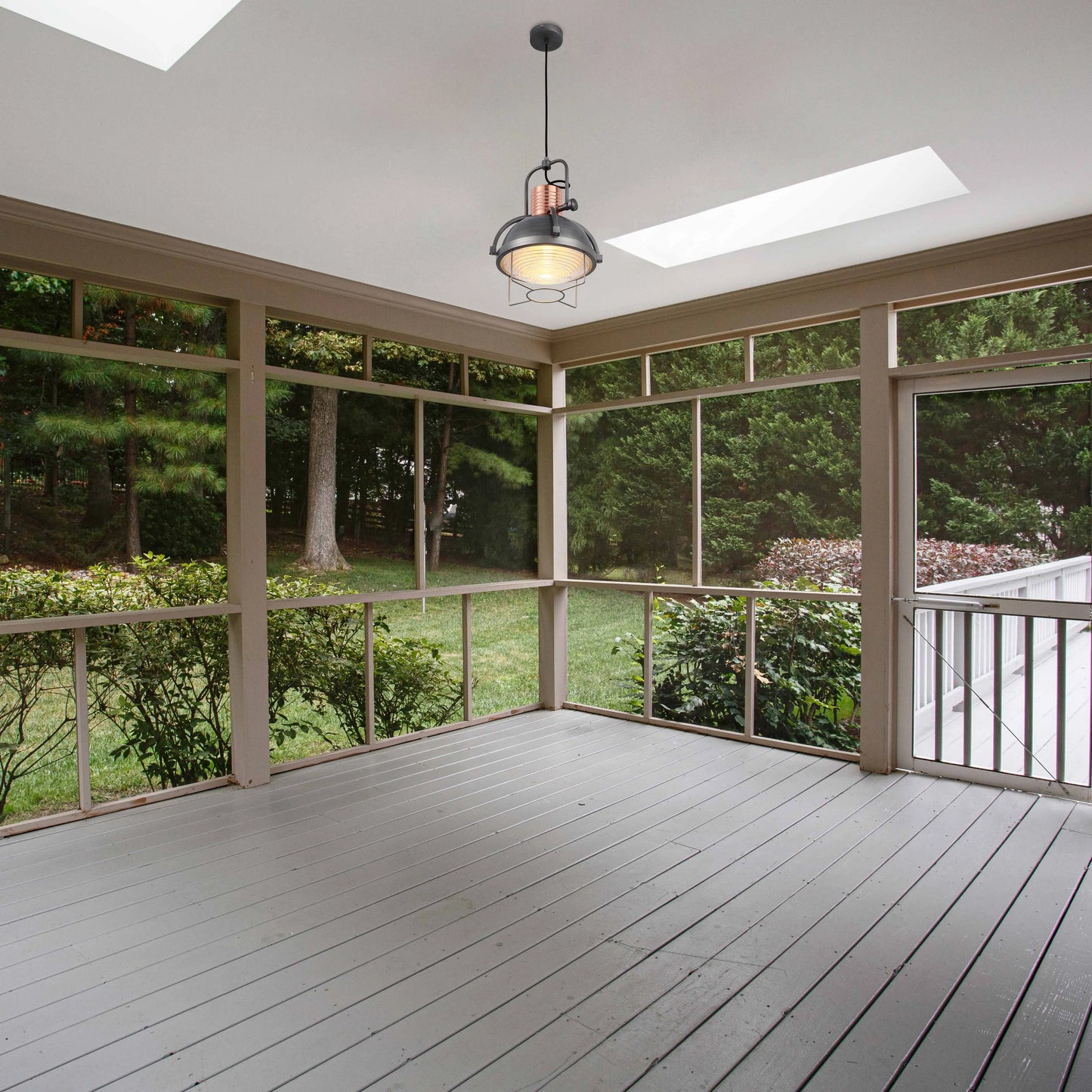 Pendant lighting with a metallic grey shade and copper detailing hangs from the ceiling of a grey deck.