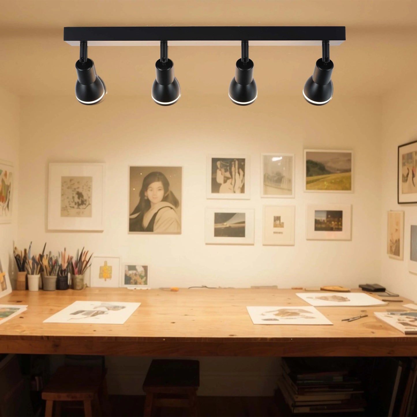 Studio with black track lighting showcasing four adjustable spotlights, ideal for illuminating artwork.
