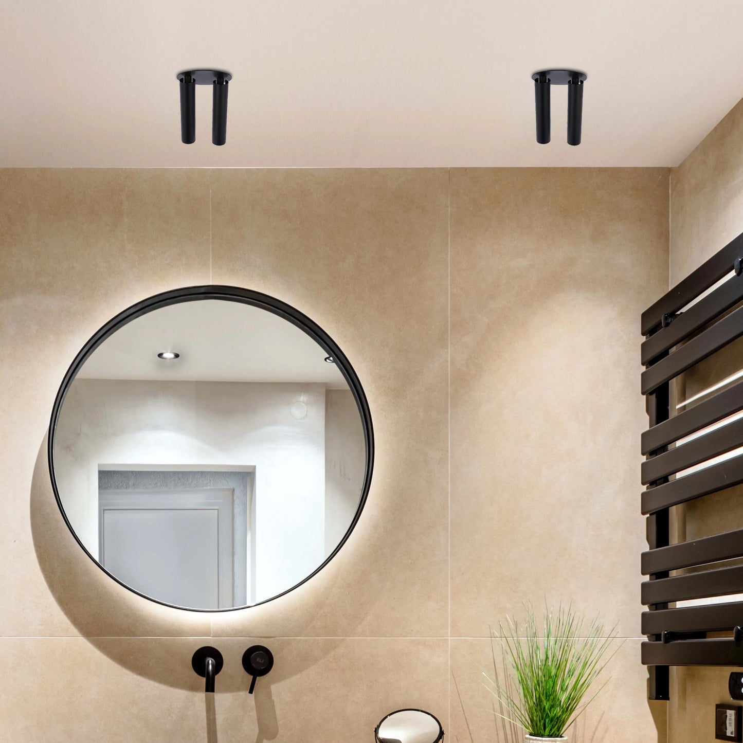 Bathroom with recessed ceiling lights, backlit mirror, and wall-mounted heated towel rail, illuminating the space in a modern style.