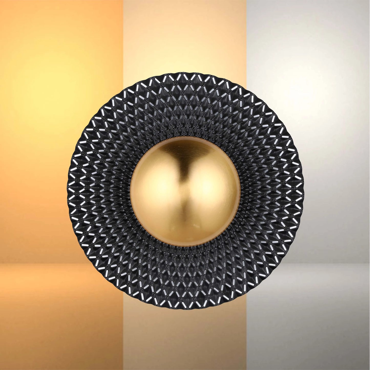 Wall-mounted feature light with black textured surround and a gold, spherical centrepiece. Warm and neutral backdrops.
