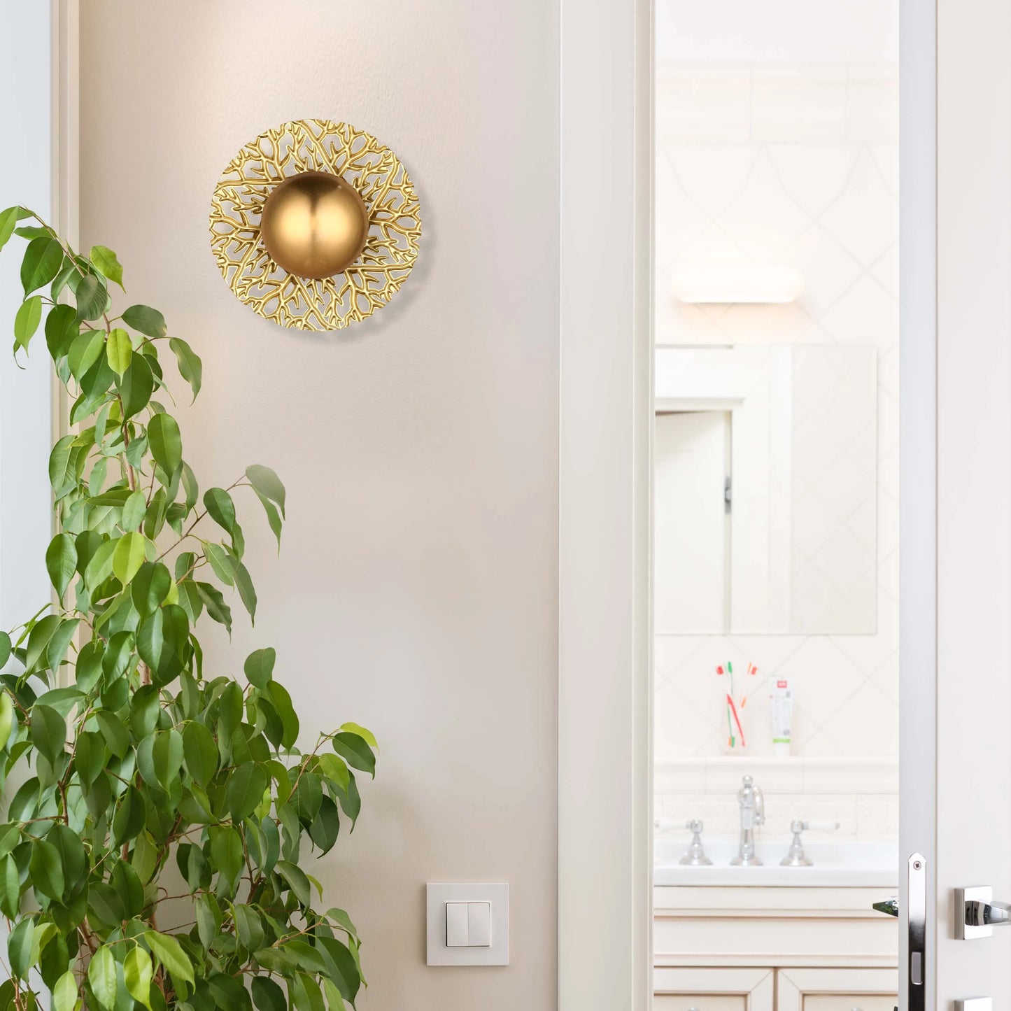 A gold wall light fixture casts a warm, inviting glow. Modern design with intricate detailing, creating a focal point in the room.