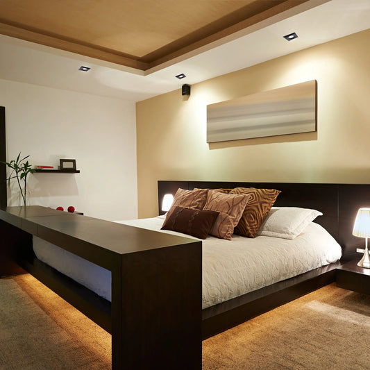 Bedroom lighting with recessed spotlights in the ceiling and bedside lamps creating a warm, inviting ambience.