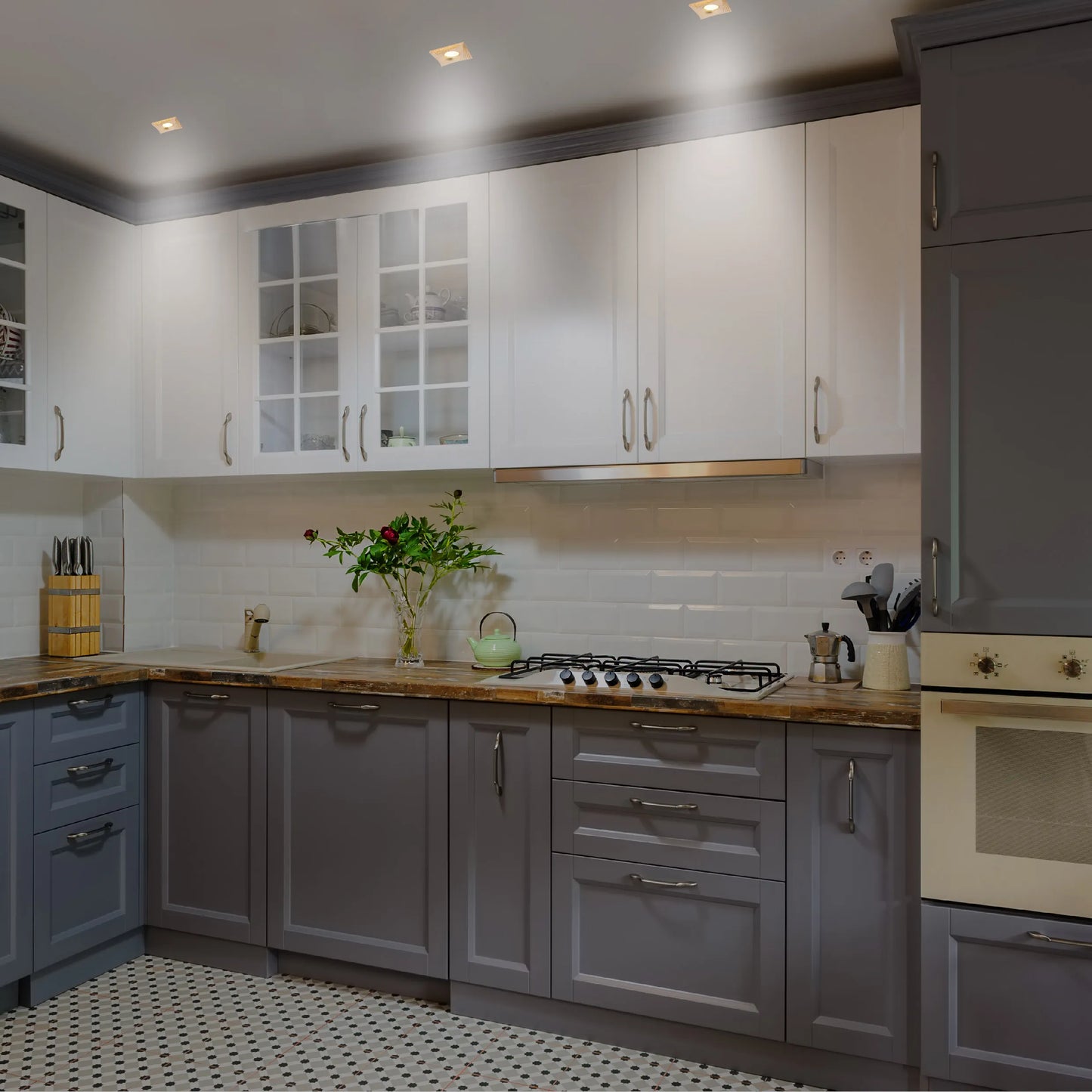 Bright kitchen lighting showcases sleek downlights above grey and white cabinets, creating a modern and inviting space.