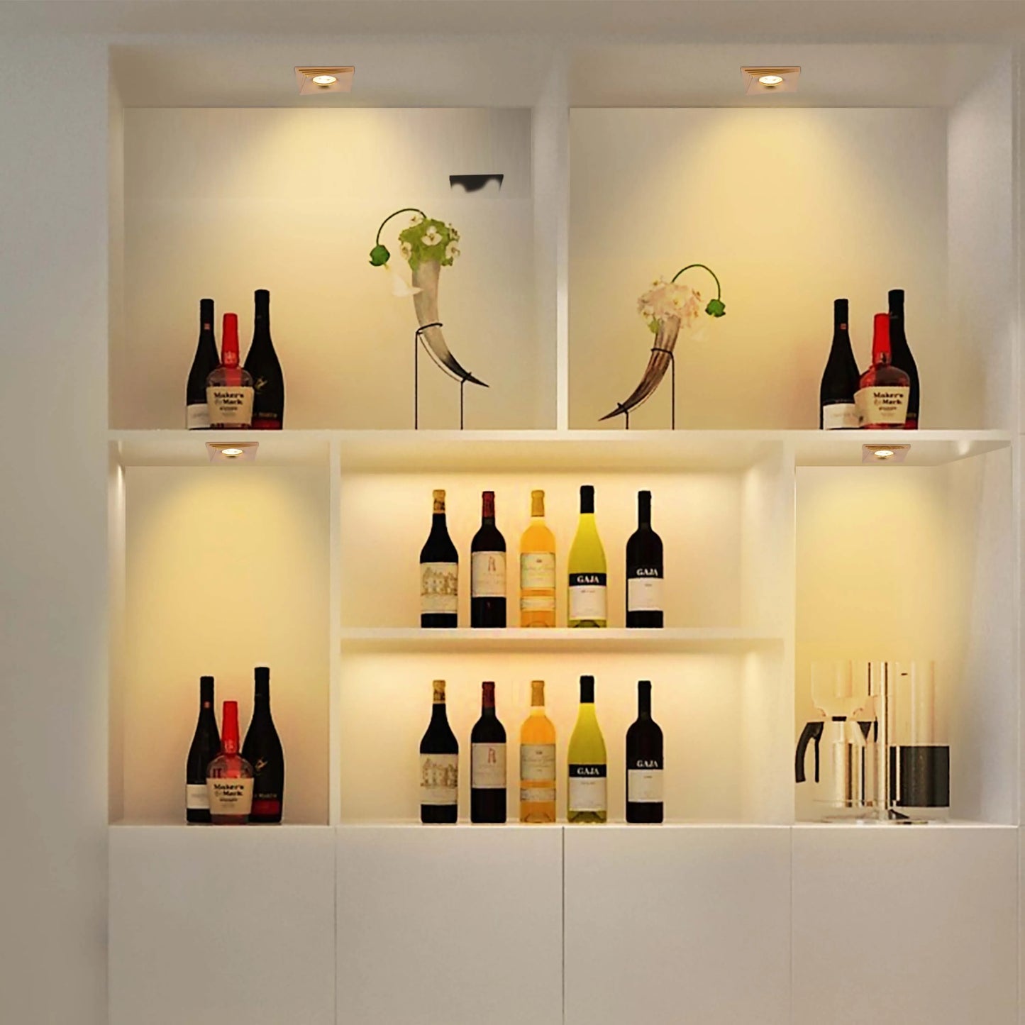 Recessed downlights illuminate alcoves displaying wine and ornaments. Warm, inviting glow creates an elegant display.