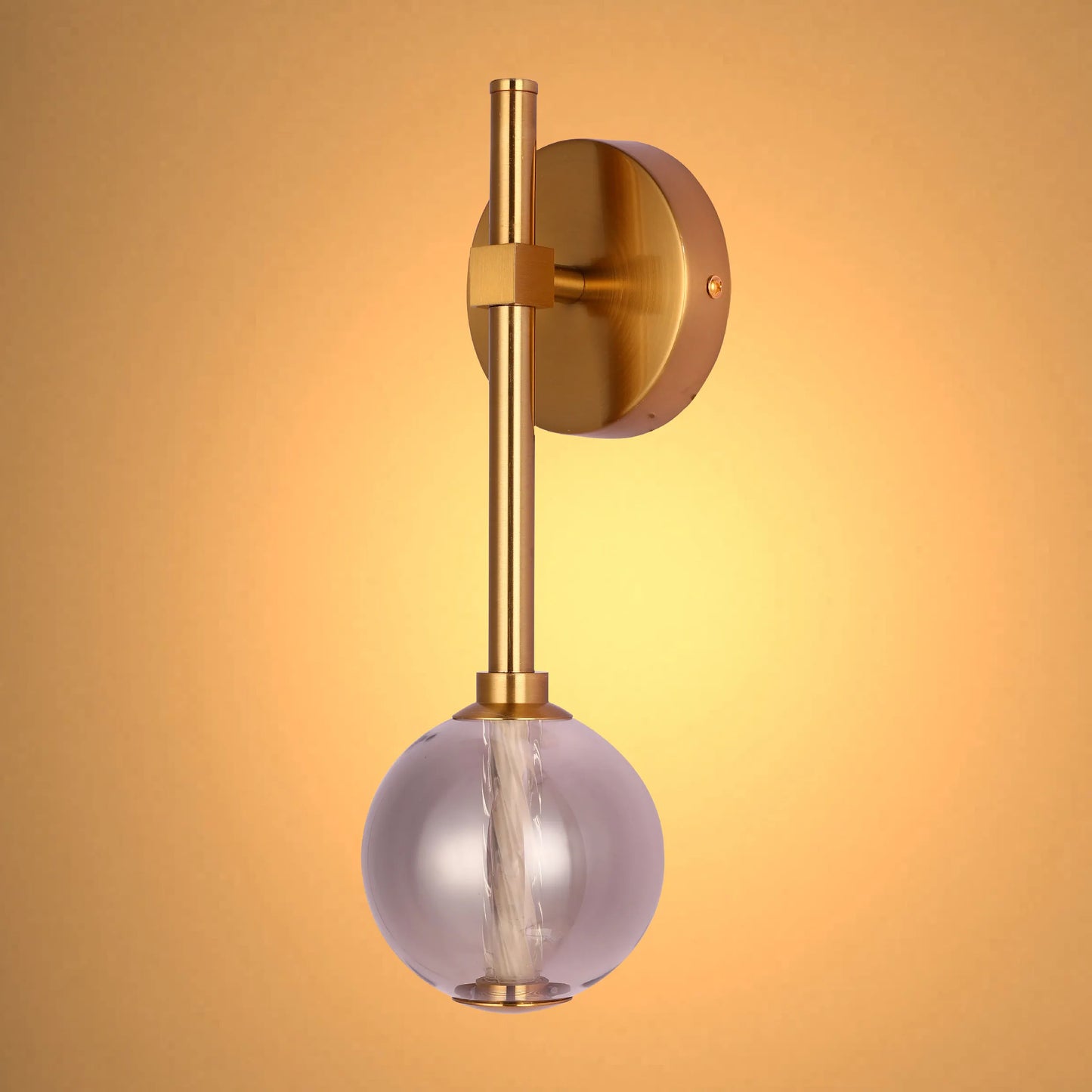 Elegant gold wall light with a smokey glass globe. Modern design that provides a warm, ambient glow for any room.