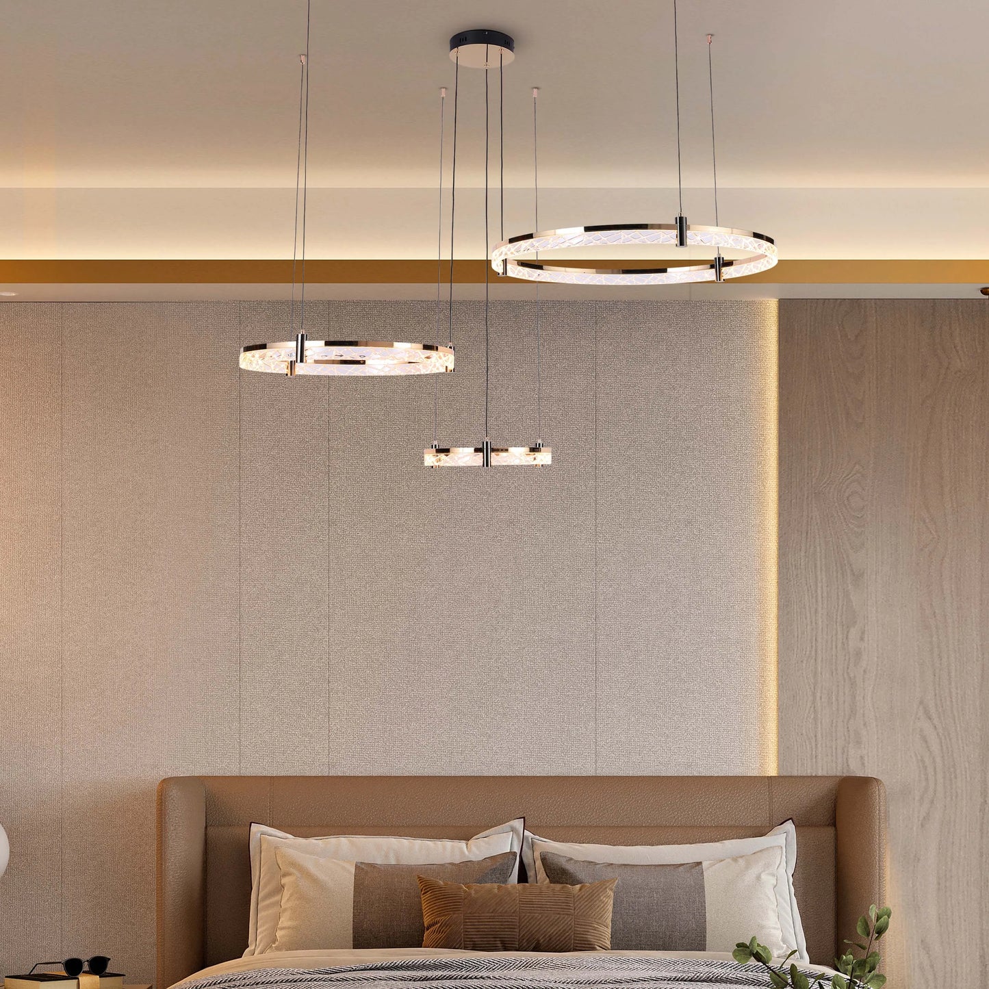 Contemporary bedroom lighting featuring three crystal and metal ring pendant lights suspended above a leather headboard bed.