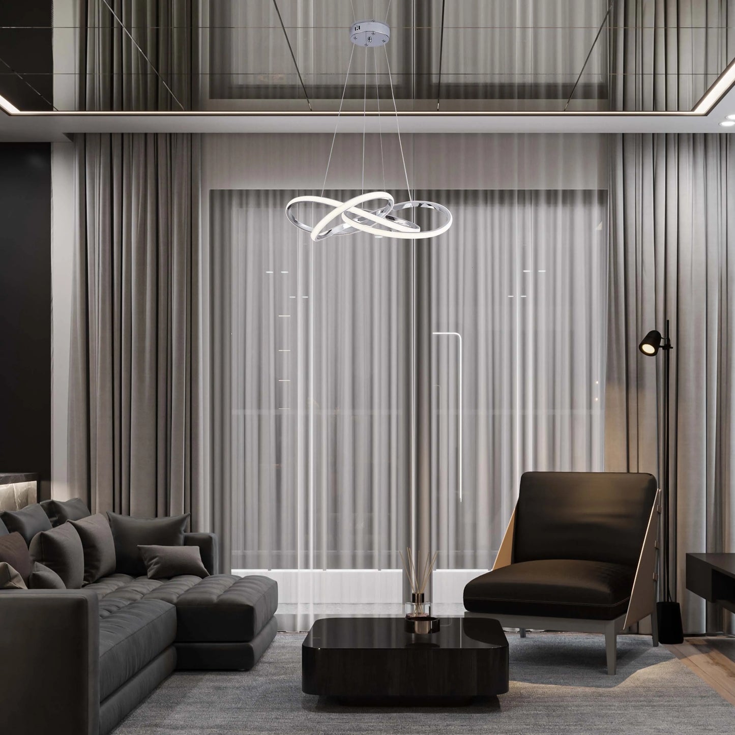 A modern, chrome, ringed chandelier hangs above a black glass coffee table in a contemporary living room. Recessed ceiling lights add to the ambiance.