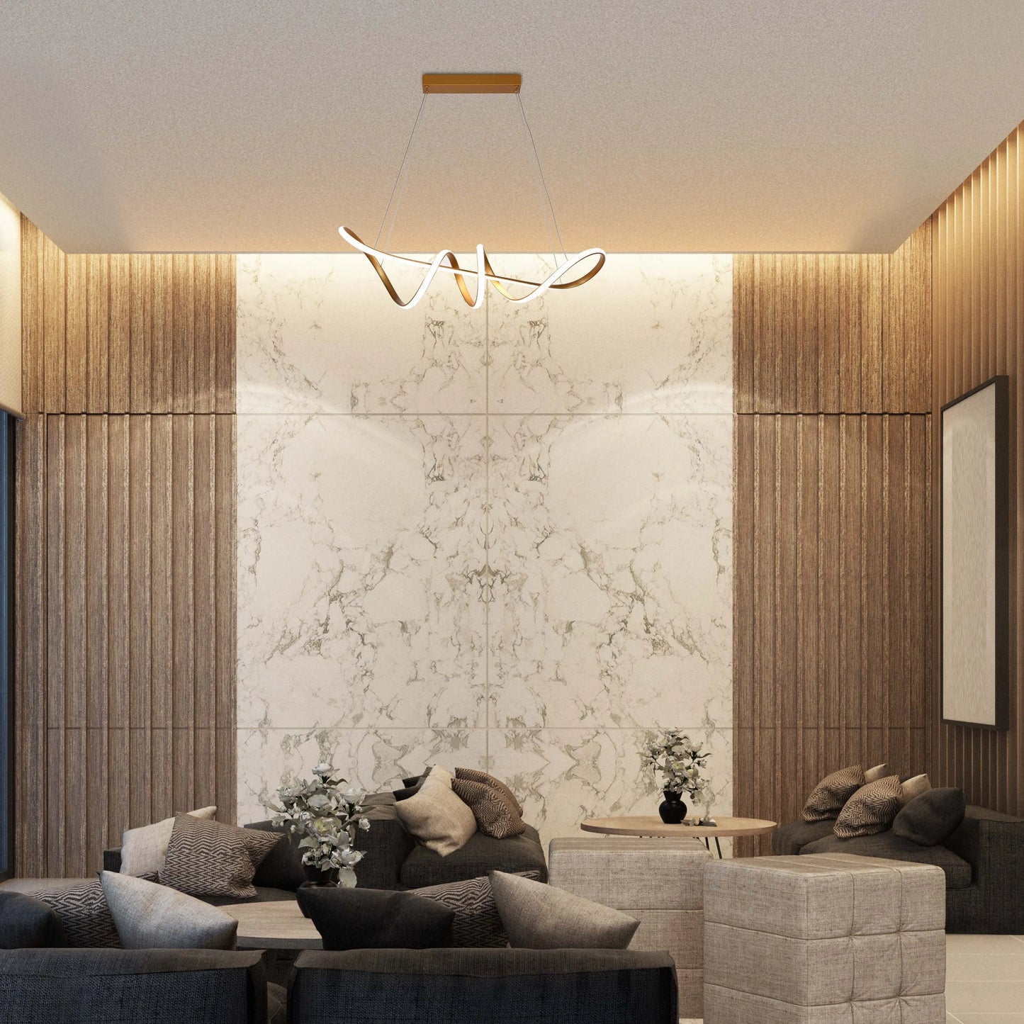 A modern, gold-toned pendant light fixture hangs above furniture in a neutrally-decorated lounge, casting a warm ambient glow.
