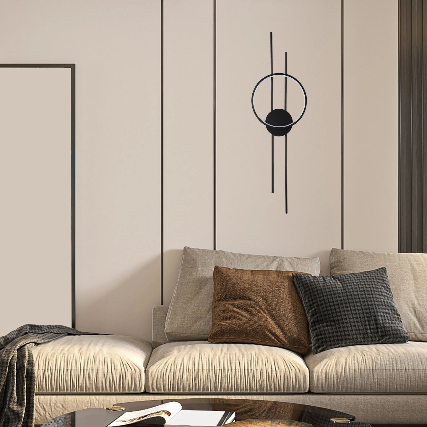 Modern wall light with matte black finish and circular design, casting a soft, ambient glow on the beige wall.