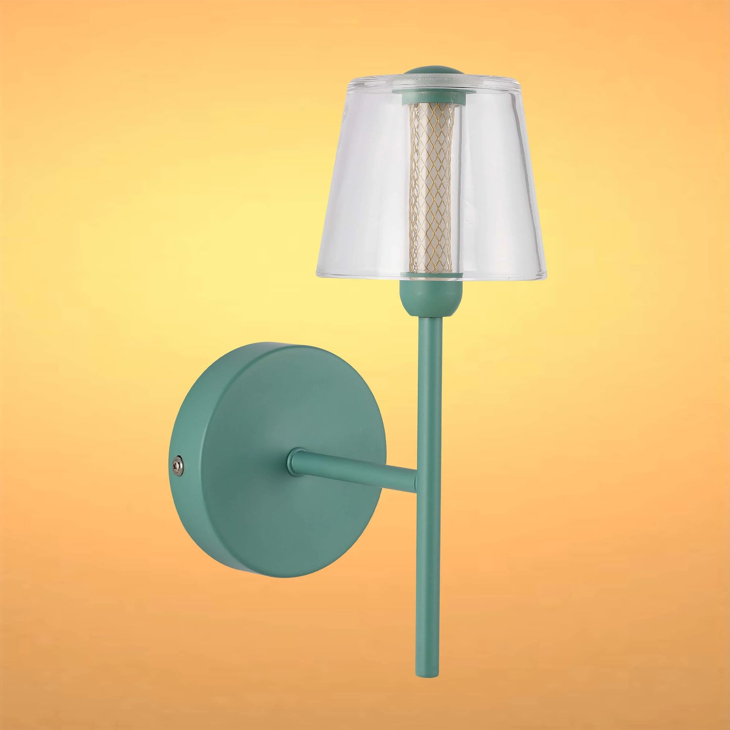 A modern wall light fixture with a clear shade and green fixture against a golden background.