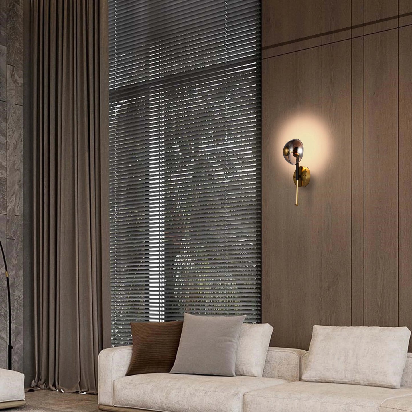 A decorative wall light provides a soft glow on the panelled wall, illuminating a neutral living room interior.
