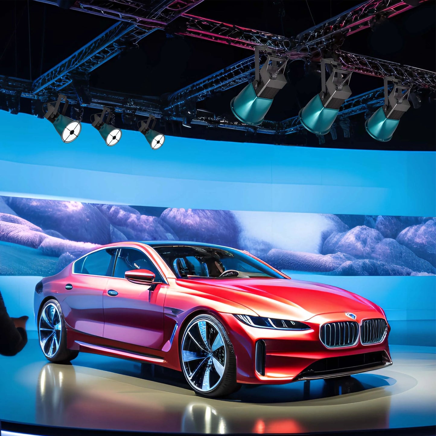 A striking display of stage lighting illuminates a sleek, red concept car. The blue hues give a high-tech feel to the scene.
