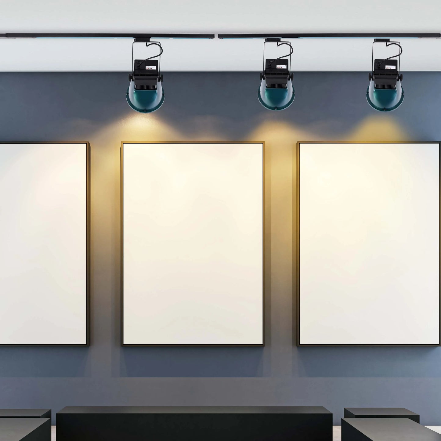 Gallery track lighting illuminates three framed artworks, highlighting the gallery’s exhibition. Perfect for art lighting solutions.