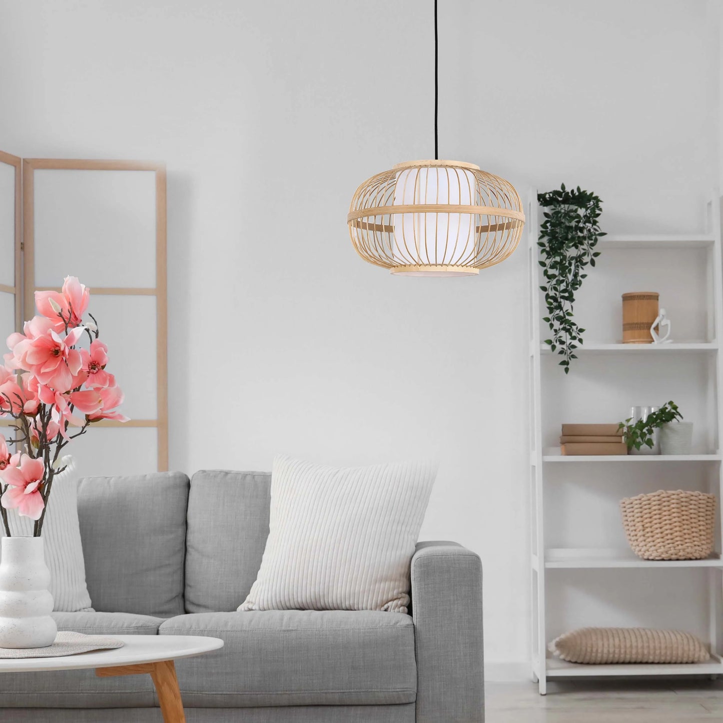 A bamboo pendant light hangs in a bright living room with white walls and neutral furnishings.