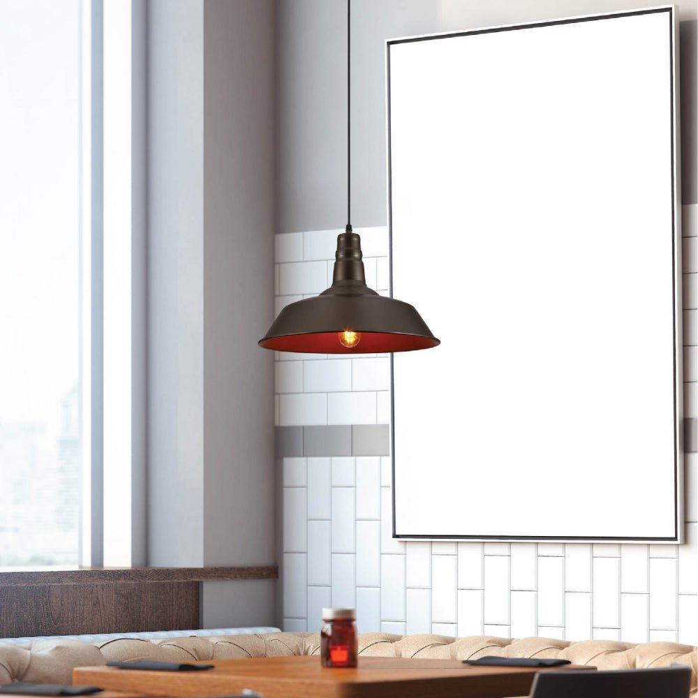 Booth seating with a light wood table, illuminated by a pendant light. A picture frame is on the wall.