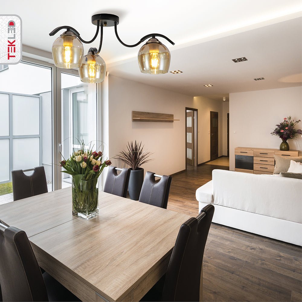 Amber glass black semi-flush ceiling light with 3xe27 fitting in indoor setting dining table top