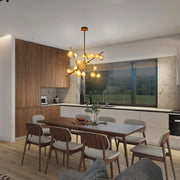 A statement sputnik chandelier with gold arms and glowing spherical bulbs illuminates a modern dining area, adding a touch of glamour.