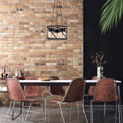 A stylish, caged pendant light in black metal with vintage-style bulbs hangs above a modern dining table, casting a warm glow.