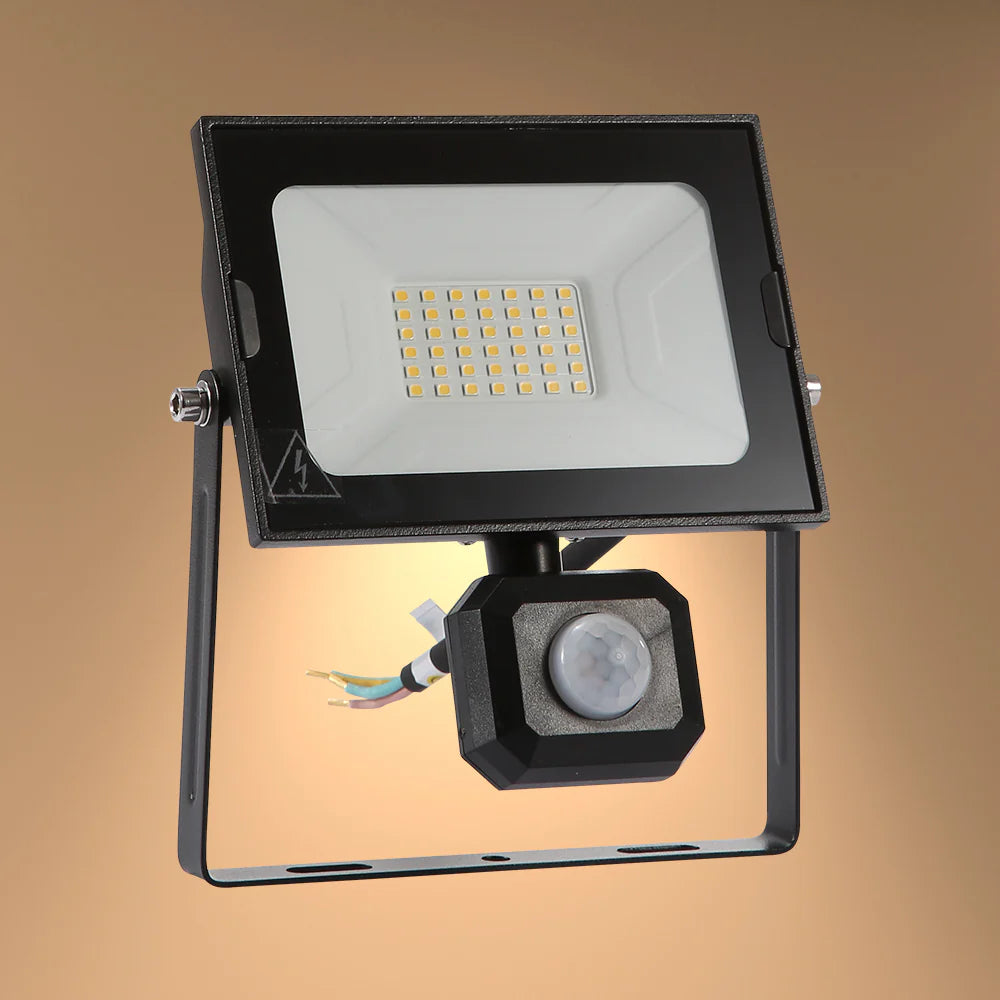 Black outdoor security light with motion sensor. Modern floodlight design provides bright, energy-efficient lighting.