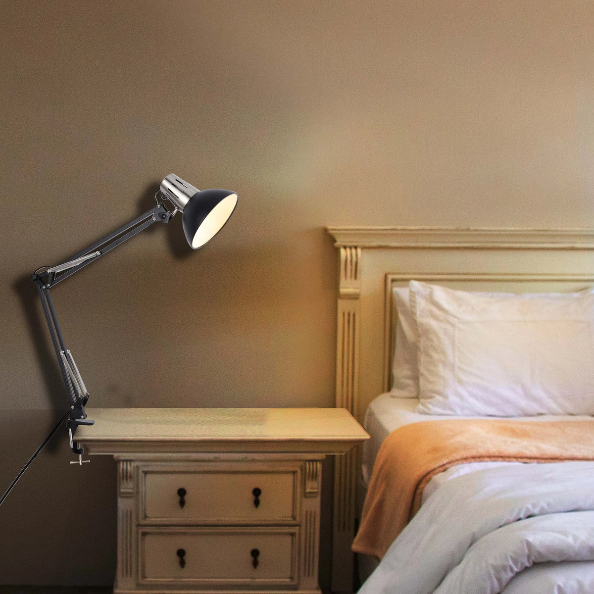 A bedside lamp casts a warm glow, highlighting textures in the neutral-toned bedroom. The light source adds depth and a cosy ambience to the space.