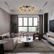 Modern living room lit by a statement black and gold flush mount chandelier with round, amber-tinted glass shades.