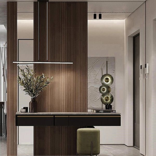 Contemporary lighting: a linear pendant, track spots and wall art with integrated lights create a well-lit and stylish entrance hall.