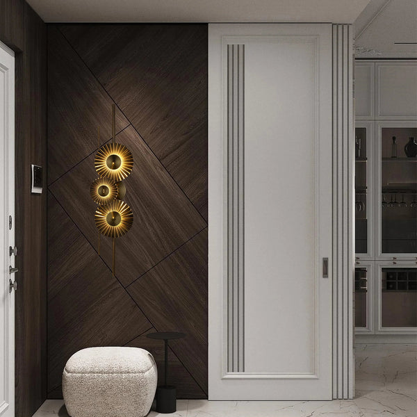 Striking wall-mounted lighting fixture featuring three circular, sunburst-style lamps with a warm, golden glow. A focal point on a dark wood panelled wall.