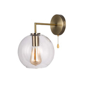 Vintage-style wall light with a spherical glass shade and aged brass fitting, complete with a traditional pull cord.