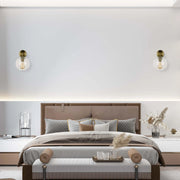 Ambient lighting: wall sconces with vintage-style bulbs flank the bed; subtle under-cabinet lighting.