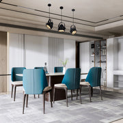 Three industrial style pendant lights hang above a dining table, providing directional downlighting in a modern dining space.