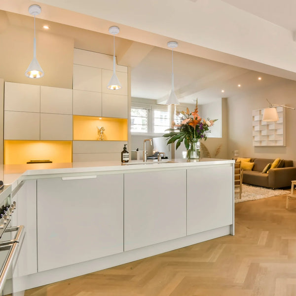 Contemporary kitchen lighting includes three cone-shaped pendant lights and in-cabinet spotlights, creating a warm and inviting atmosphere.
