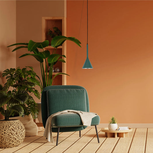 A teal pendant light illuminates this interior living space, complementing the plants and textured walls.