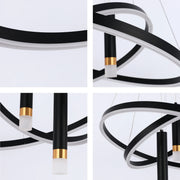 A modern circular LED chandelier. It features black hoops, white accents, and cylindrical lamps with gold bands.